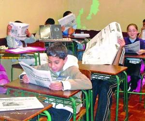 Foto dos alunos trabalhando com jornal em sala de aula.